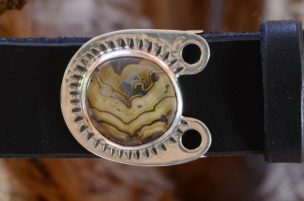 Silver Belt Buckle with Schwenblende stone in creams, blue, red and gold colors. Displayed with a black leather belt.