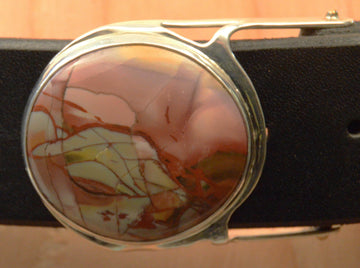 Close-up of round mescalero jasper cabochon belt buckle with brown leather belt.