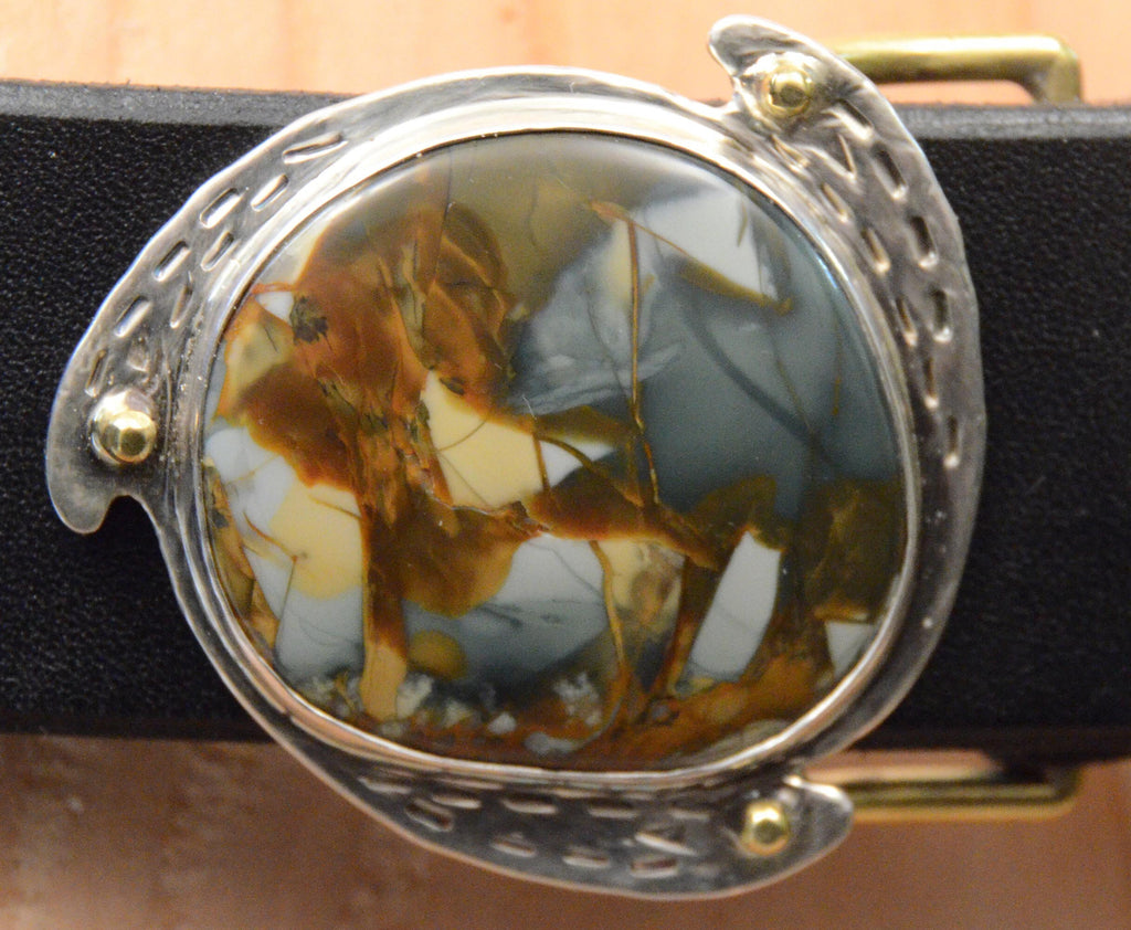 Round silver belt buckle with dramatic morrisonite jasper stone in deep blue, grays, oranges and gold colors.